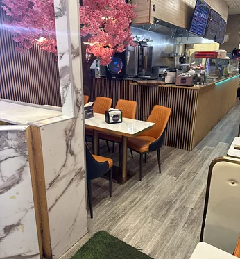 Dining room with orange chairs and the shawarma counter