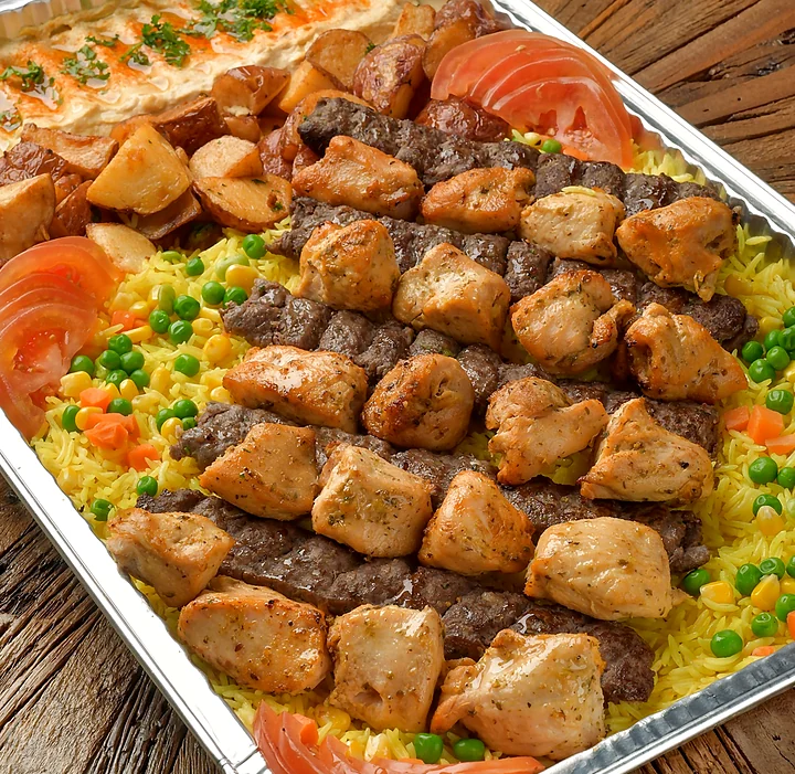 Tray of beef kabab and chicken shish tawook over rice with garlic potatoes